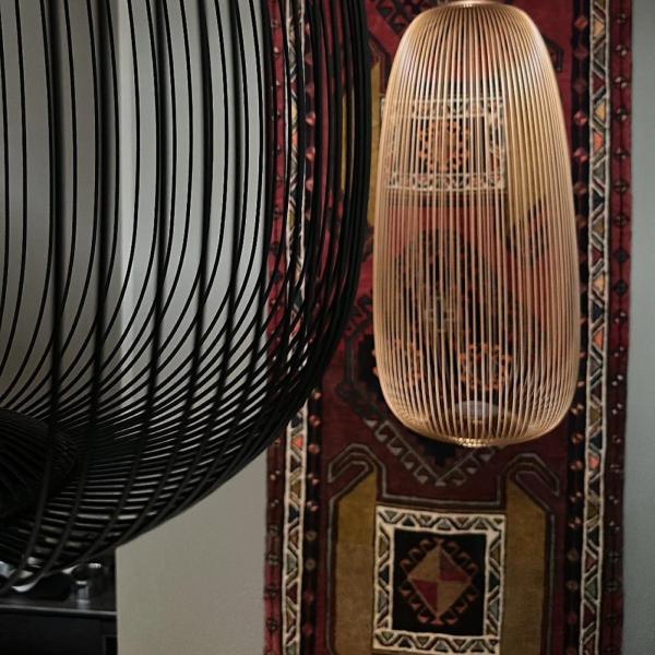 Orientalsk tæppe med geometrisk mønster som vægteppe bag designer hængelamper.