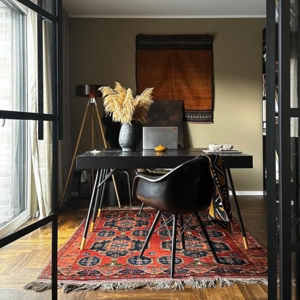 Orientális szőnyeg piros és sötétkék medál mintákkal a modern dolgozószobában
