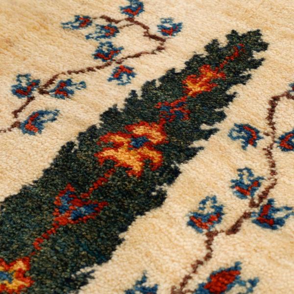 Nærbillede af et Gabbeh-tæppe med blomster mønstre.