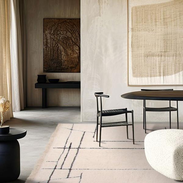 Tapis de designer moderne en beige avec un motif de lignes noires dans un salon minimaliste.