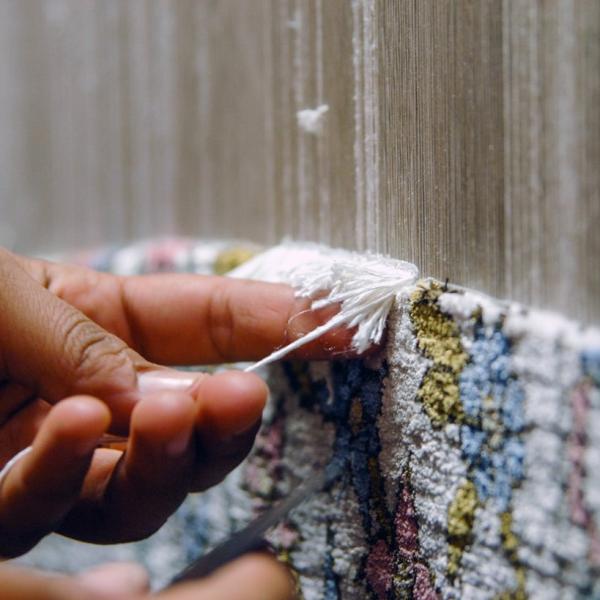 Håndknude af tæpper – Nærbillede af fremstillingsprocessen for et højkvalitets persisk tæppe