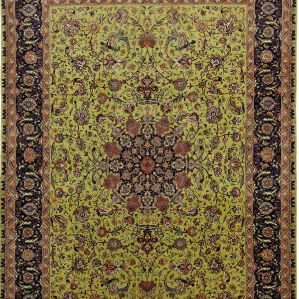 Gros plan d'un tapis Tabriz noué à la main en vert avec un motif de médaillon classique.