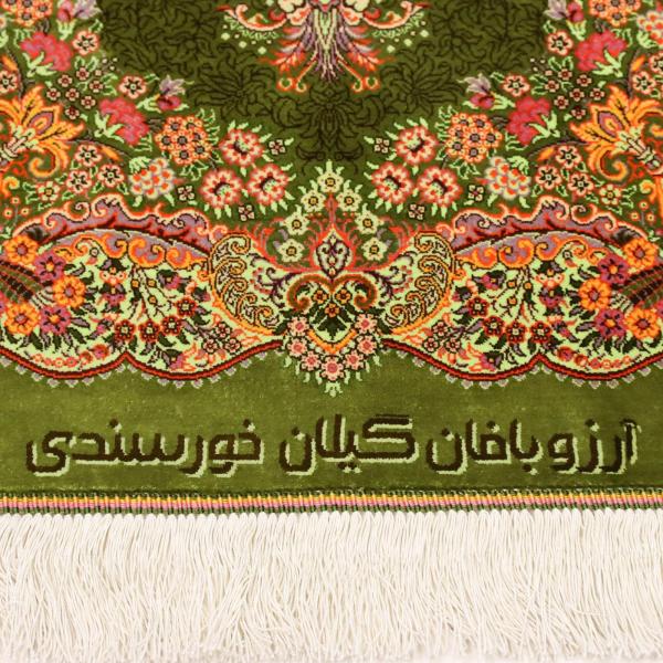 Belle signature de tapis persan sur un tapis en soie verte avec une ornementation florale aux couleu