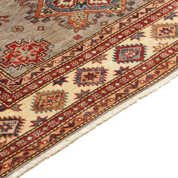 Detaljevisning af et håndknyttet Kazak tæppe med geometrisk båndmønster i rød, blå, beige.