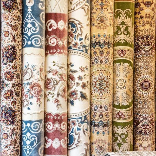 Rullet række af orientalske tæpper med blomster mønstre