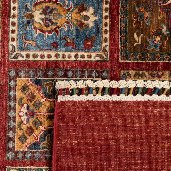 Nærbillede af et foldet håndknyttet orientalsk tæppe med traditionelle mønstre