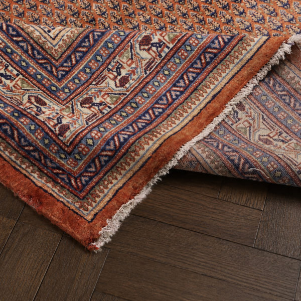 Traditioneller orientalischer Teppich auf dunklem braunen Parkettboden