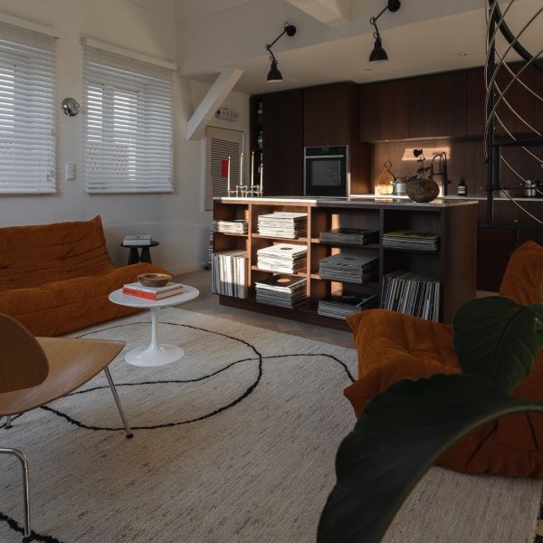 Style rétro dans le salon d’un appartement mansardé avec un tapis élégant au centre