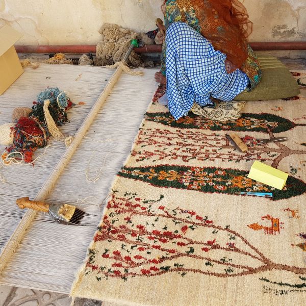 Fabricación tradicional de una alfombra oriental anudada a mano en el telar de nudos