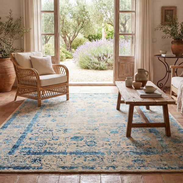 Salon aménagé dans un style méditerranéen avec un tapis bleu roi remarquable au motif losanges