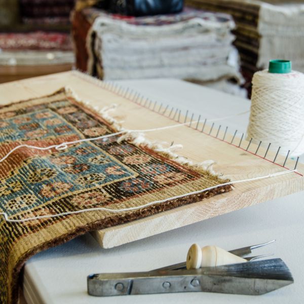 Restauración profesional de una alfombra oriental anudada a mano en un taller especializado en alfom