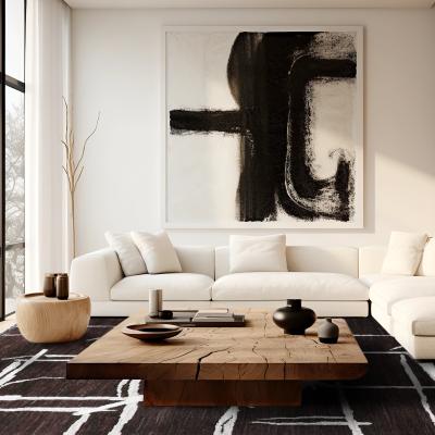 Minimalistisk stue med beige sofa, stort abstrakt sort-hvidt maleri og sort bænk.