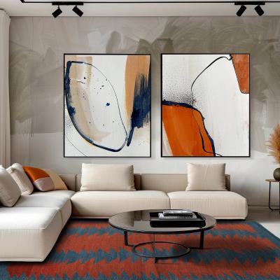 Kunstnerisk stue med moderne zigzag-tæppe i orange og blå, abstrakte lærreder på væggen og hvid sofa