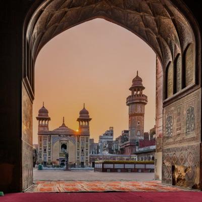 Egy történelmi mecset díszített ívvel és keleti szőnyegekkel a imaterületen.