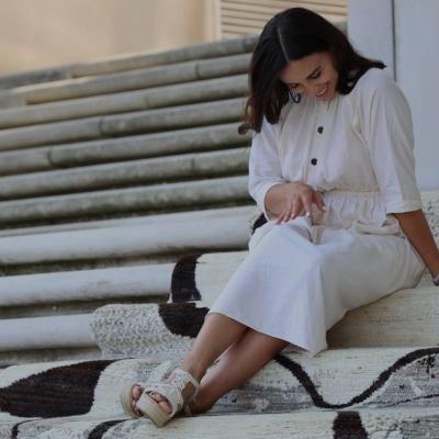 Designer sidder på trappen dækket med abstrakt mønstret tæppe.