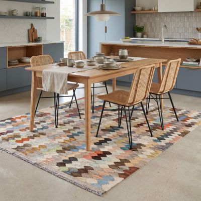 Barevný afghánský koberec Kilim ve světlé moderní jídelně.