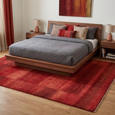 A modern bedroom with a red designer rug.