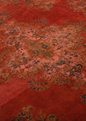 Vintage Kerman szőnyeg részletes nézete rozsdavörös színben, virágos medálmintákkal.