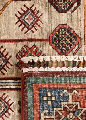 Nærbillede af et Ziegler-tæppe med indvævede rhombusmønstre og frynseafslutning.