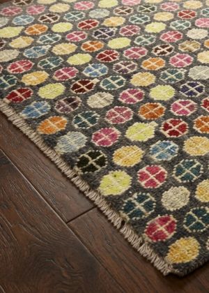 A colourful designer rug on dark brown parquet flooring.