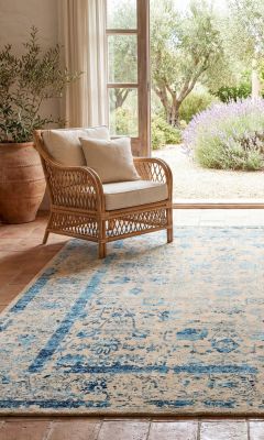 Modern designer rug in the living room with a rattan armchair